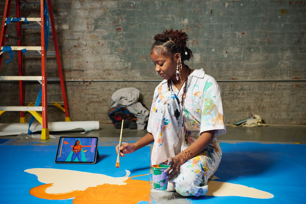 A young artist paints a butterfly on Arts New Orleans’ new mural.