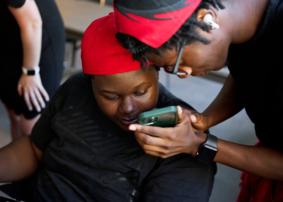 Glen-David Hardy-Covington und John Johnson schauen auf ein iPhone.
