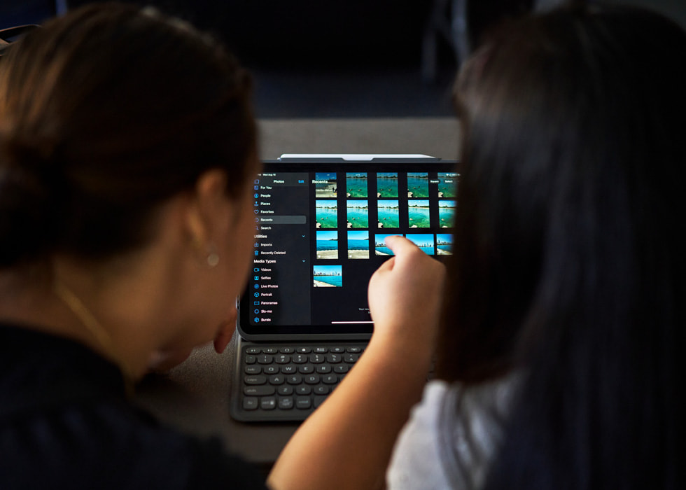 Zwei Personen mit einem iPad bei der Fotobearbeitung.
