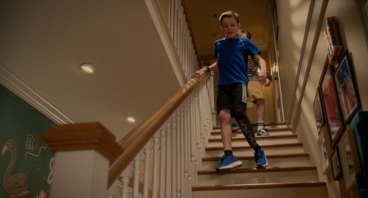 Scene from Best Foot Forward, young boy with prosthetic leg walking downstairs with his friend