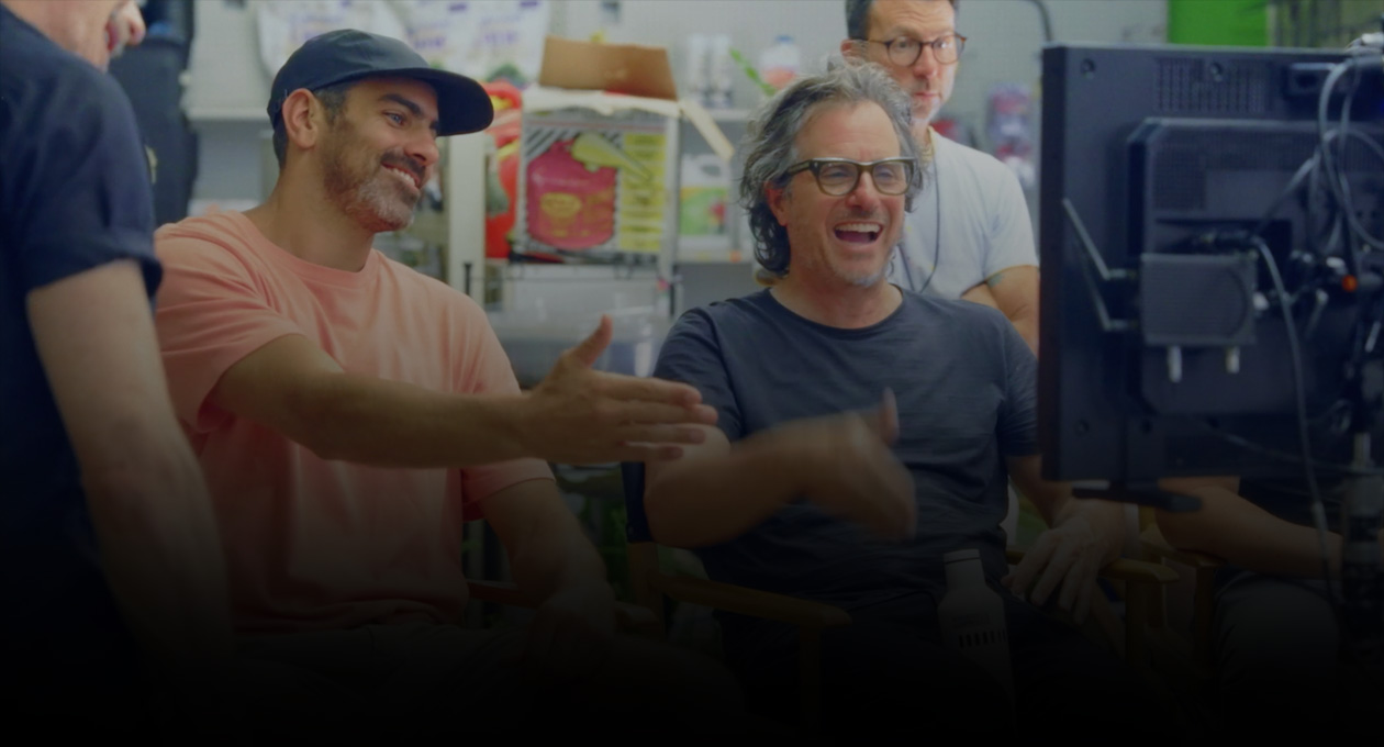 Bild von zwei Filmemachern, die vor dem Bildschirm sitzen und sich in Gebärdensprache unterhalten.