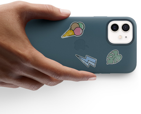 Hand holding an iPhone 12 with stickers.