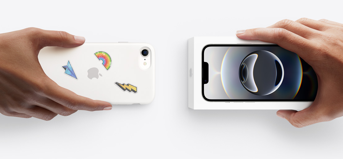 보상 판매 기기를 교환하는 두 손. 뒤에 스티커를 붙인 실리콘 케이스를 씌운 iPhone 13을 상자에 든 iPhone 17과 교환하고 있습니다.