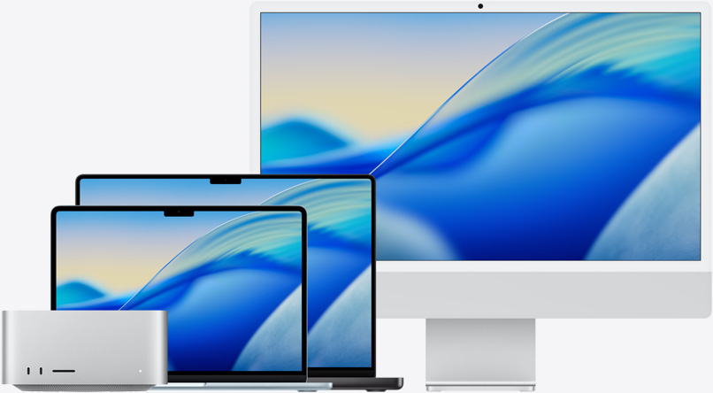 The macOS Tahoe wallpaper across family of Mac models from left to right: Mac Studio, 13-inch MacBook Air in Sky Blue, 14-inch MacBook Pro in Space Black and 24-inch iMac in Silver